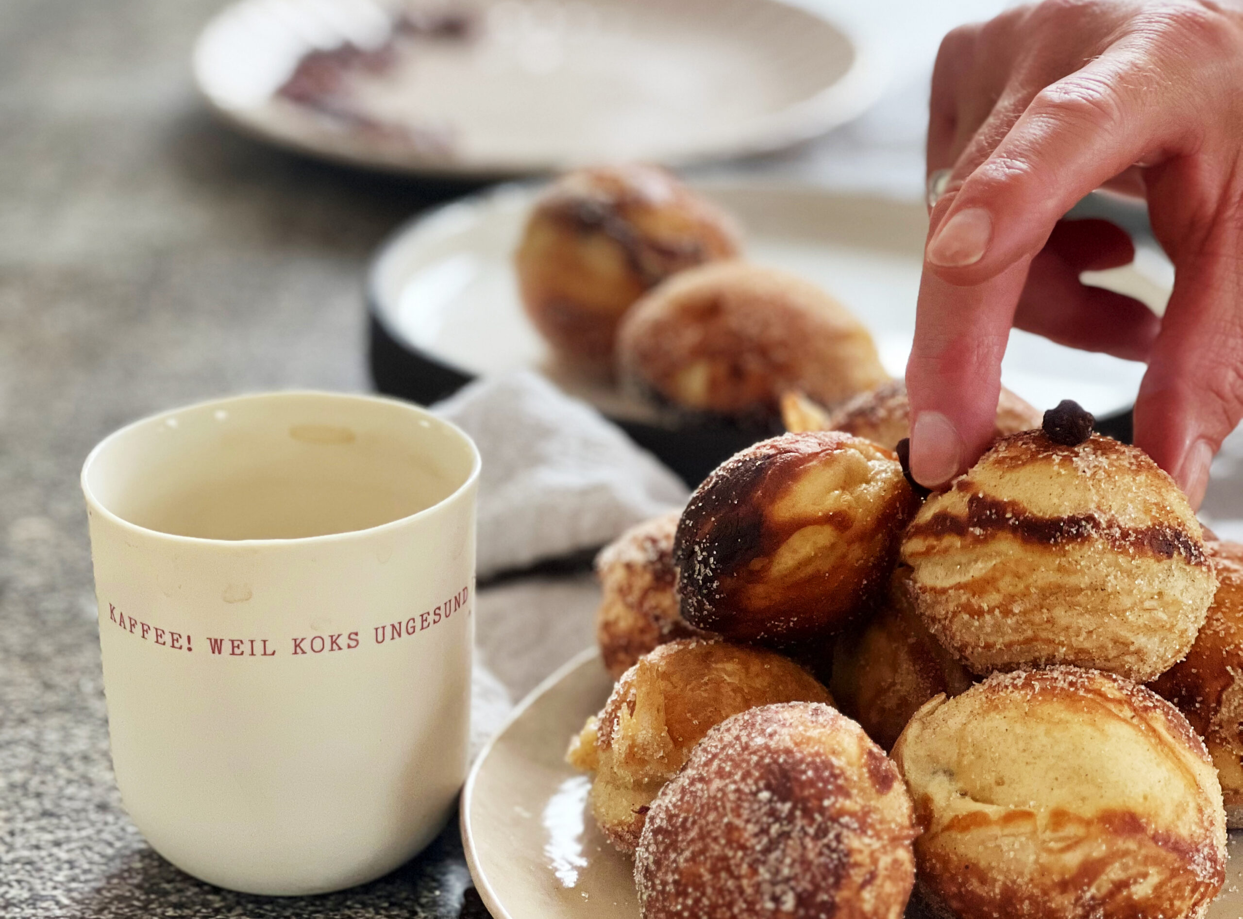 Fertige Förtchen auf Teller neben Kaffeebecher